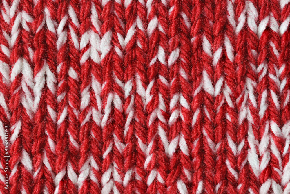 Mottled red and white knitted texture. Marl yarn knitting. Colorful background. Closeup 