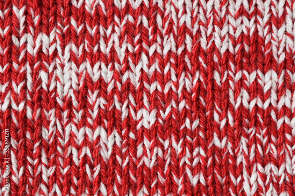 Mottled red and white handmade knitted texture. Marl yarn knitting. Colorful woolen fabric background. 