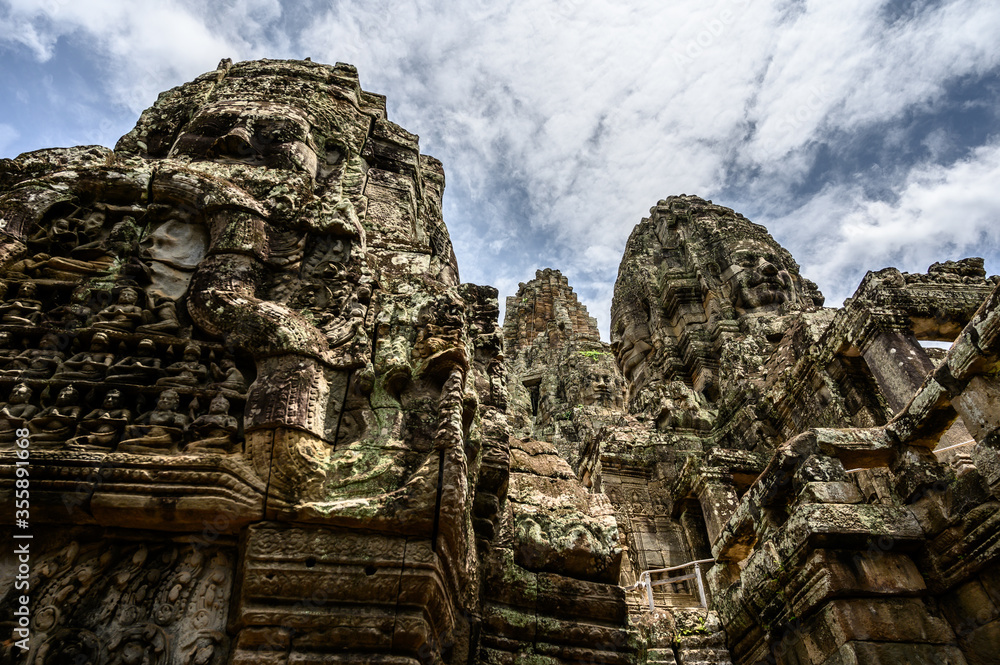 Towers with faces cravings of the ancient temple Angkor Thom next to the Angkor Wat in Siem Reap, Cambodia. Stone build old Khmer temple.