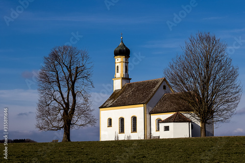 Fotografia, Obraz small chapel  against a blue sky in upper bavaria