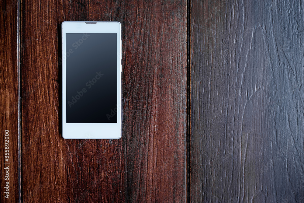 Digital technology. Close up of white smartphone on the wooden table. Digital technology. Close up of white smartphone on the wooden table.