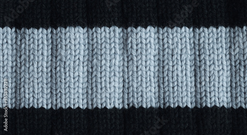 Gray and black knitted woolen background. Detailed wavy knit elastic texture. Handmade dense knitting of thick yarn.Closeup. Copy space 