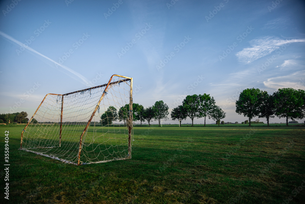 soccer football goal in rural country sunrise on local town village green pitch
