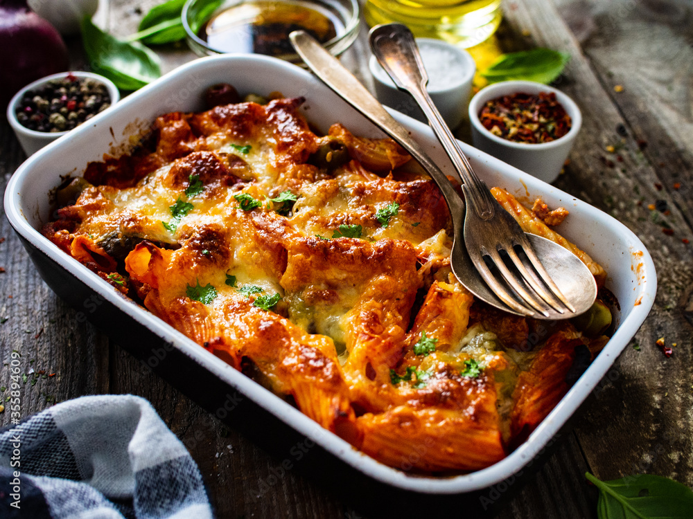 Pasta casserole with minced meat, mozzarella cheese and vegetables on wooden table
Pasta casserole with minced meat, mozzarella cheese and vegetables on wooden table