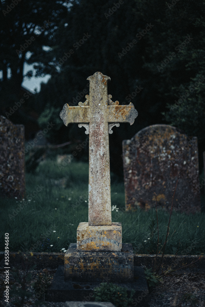 gravestone cross in cemetery graveyard in evening gravestone cross in cemetery graveyard in evening