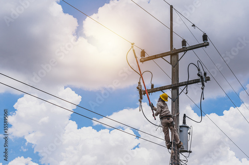 The power lineman use clamp stick (insulated tool) to closing a transformer on energized high-voltage electric power lines. The power lineman must be trained because it is a risky job.