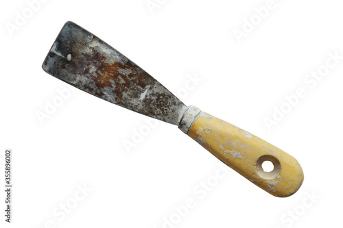 Dirty rusty spatula with wooden handle isolated on a white background. Used small putty knife stained with old plaster, rust and sealant. Closeup. Copy space
