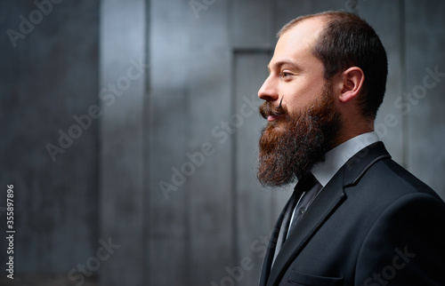 Gentleman fashion and style. Handsome young bearded man at suit and tie.