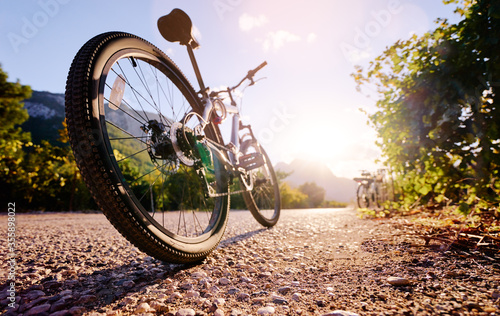 Healthy lifestyle. Close up of mountain bicycle on the road against sunny sky.