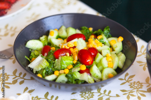 Healthy green salad. bowl of salad with vegetables and greens on table