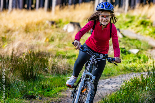 Healthy lifestyle - teenage girl biking in forest 