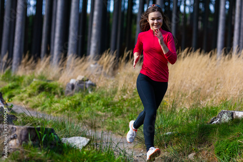Fototapeta Naklejka Na Ścianę i Meble -  Young woman running in forest
