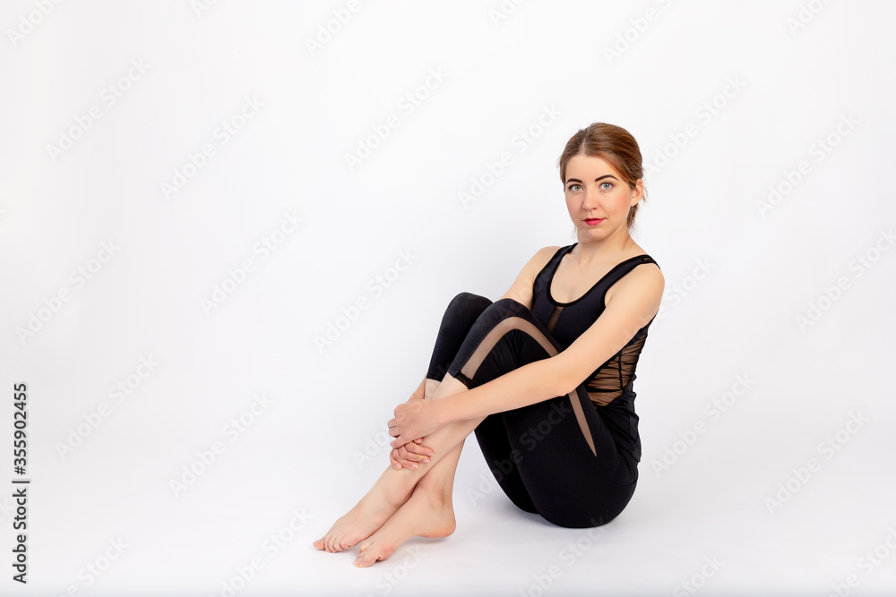 Obraz premium athletic girls sitting after a sports workout on a white isolated background, space for text
