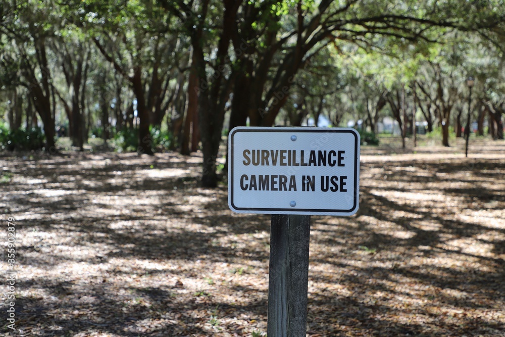 Surveillance camera warning sign in public park