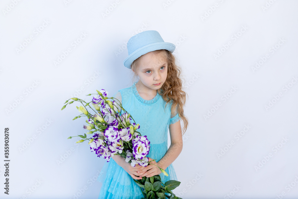 sad girl 5-6 years old in a blue dress and hat on a white isolated background holding a bouquet of flowers, space for text sad girl 5-6 years old in a blue dress and hat on a white isolated background holding a bouquet of flowers, space for text