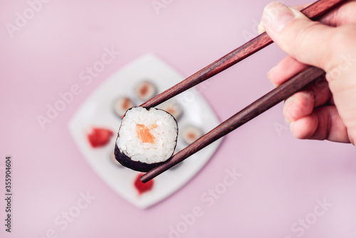 Female Hand Holding Sushi Japanese Food Sushi with Salmon Top View Horizontal