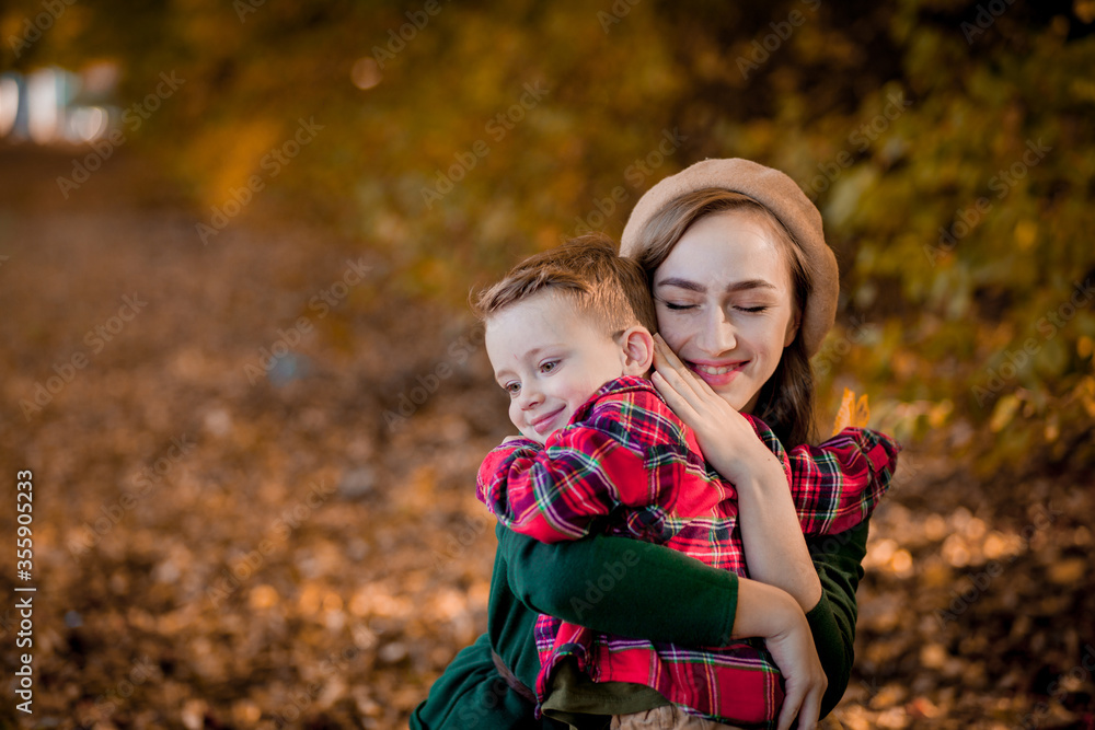 Happy young mother playing and having fun with her little baby son on sunshine warm autumn day in the park. Happy family concept, Mother's Day Happy young mother playing and having fun with her little baby son on sunshine warm autumn day in the park. Happy family concept, Mother's Day