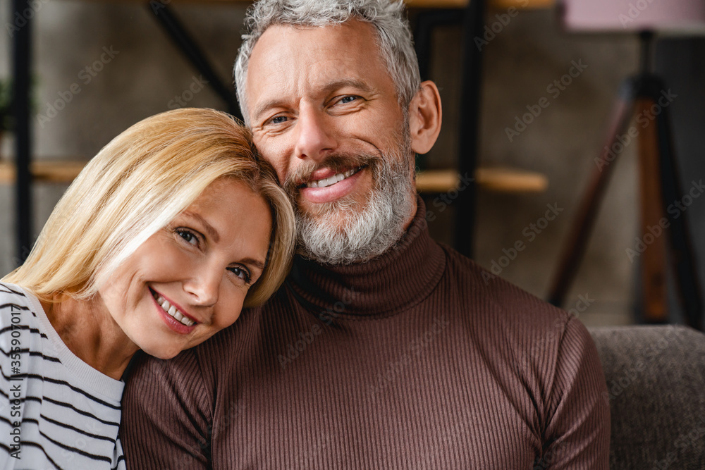 Portrait of middle aged couple bonding on couch at home living room Portrait of middle aged couple bonding on couch at home living room