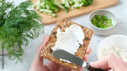 Spreading cream cheese on rye cracker crispbread. Healthy snack
