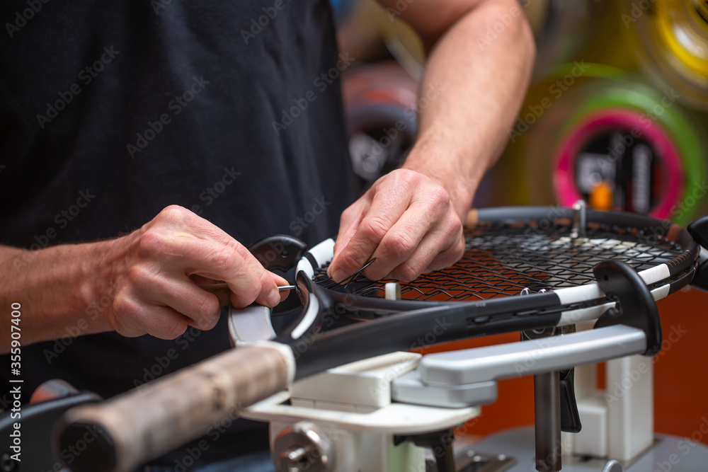 Process of stringing a tennis racket in a tennis shop, sport and leisure concept Process of stringing a tennis racket in a tennis shop, sport and leisure concept