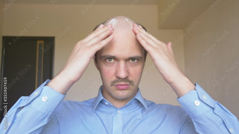 portrait. bald mustachioed man puts cream on his head portrait. bald mustachioed man puts cream on his head