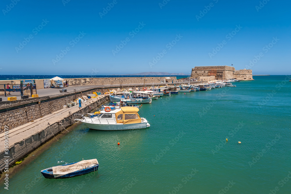 Boats and promenade near the fortress in the sea