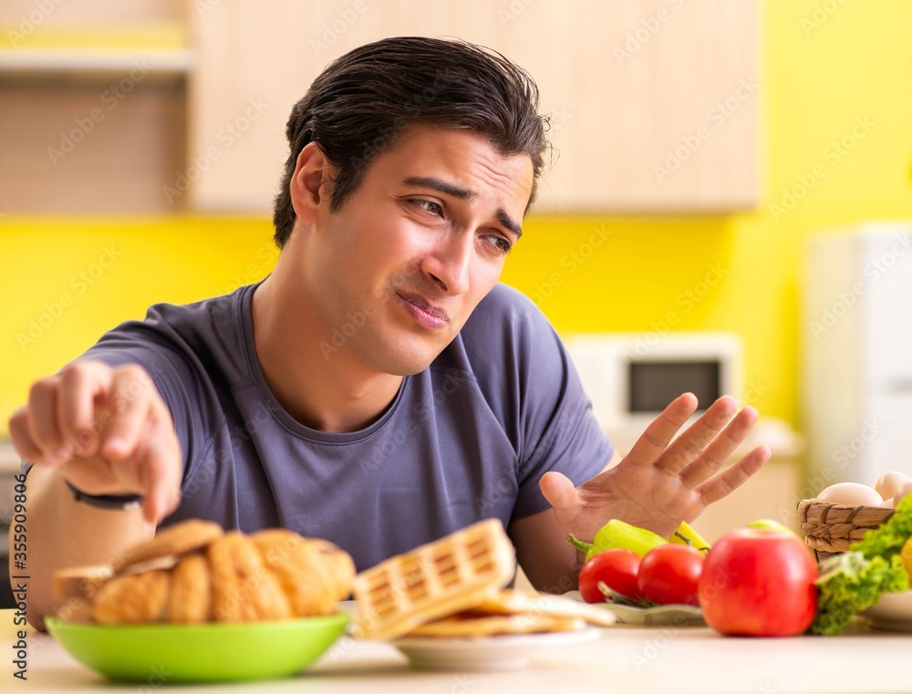 Man having hard choice between healthy and unhealthy food Man having hard choice between healthy and unhealthy food
