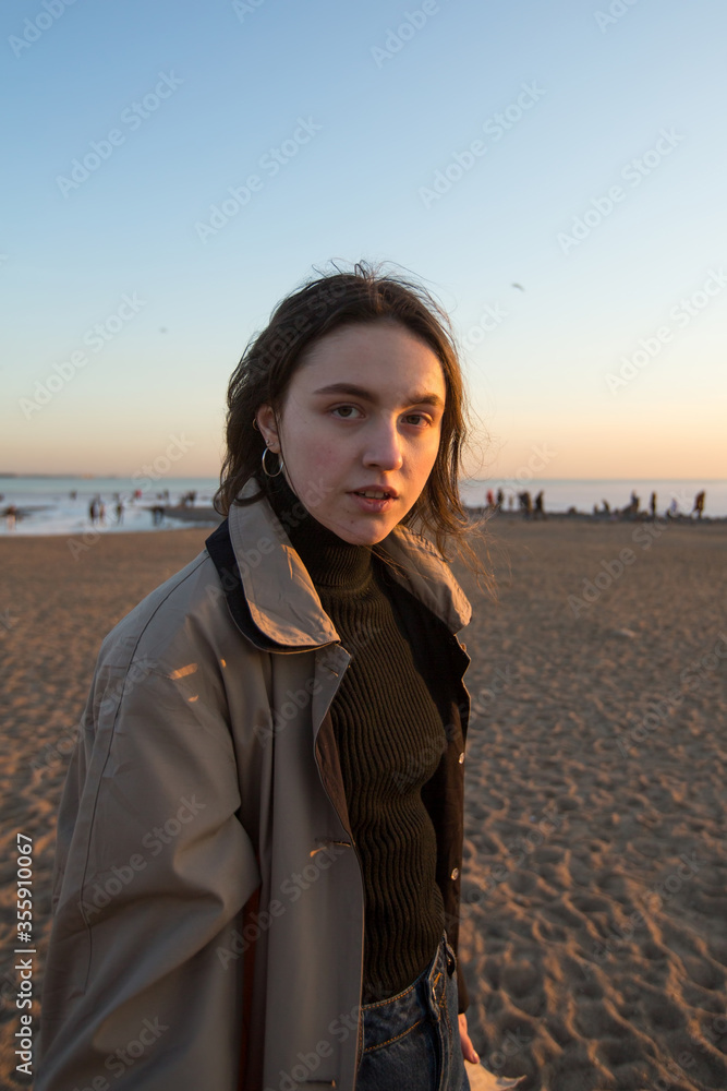 Young woman portrait in wearing a cloak on the autumn sea coast. Young woman portrait in wearing a cloak on the autumn sea coast.