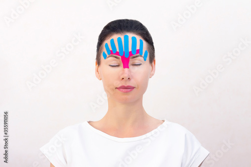 Face taping, close-up of a girls face with cosmetological anti-wrinkle tape. Face aesthetic taping. Non-invasive anti-aging lifting method for reduction of wrinkles