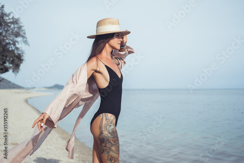 Beauty woman posing in the beach, fashion dress, hat, tattoo, happy face, smile, sunglasses