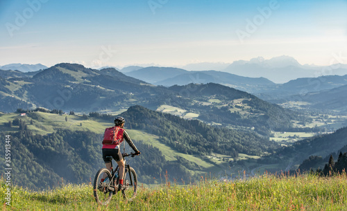 pretty senior woman riding her electric mountain bike on the mountains above Oberstaufen, Allgau Alps, Bavaria Germany 
 photo