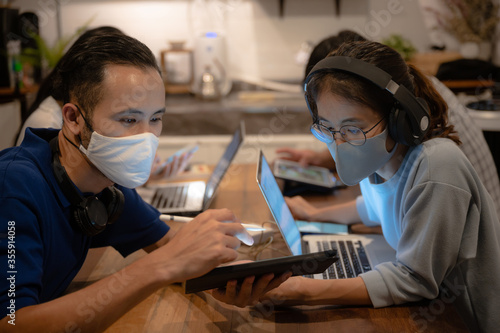 Creative designer business worker, working in spaced and wearing a medical face mask To prevent the spread of the coronavirus COVID-2019, Home office for small people group to work from home