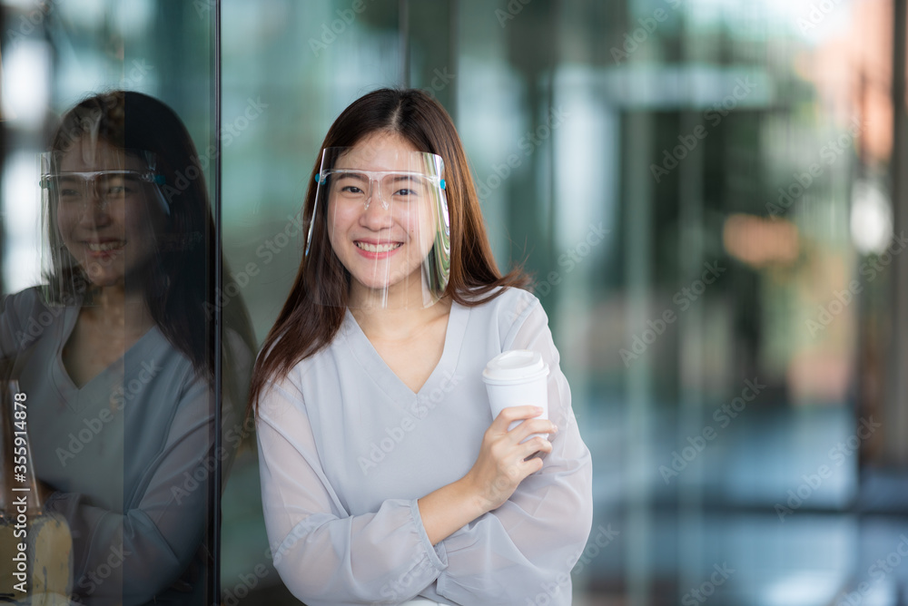 Asian women wearing face shield at the coffee cafe, a way to prevent communicable diseases but still be able to lead a new normal life, coronavirus COVID-19 communicable disease prevention