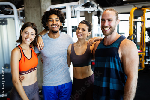 Beautiful fit people working out in gym together
