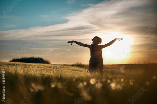 Happy woman enjoying the life in the golden field