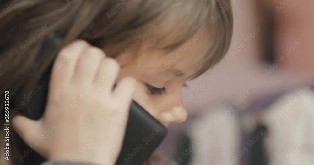 Adorable little girl talking on the smartphone Adorable little girl talking on the smartphone