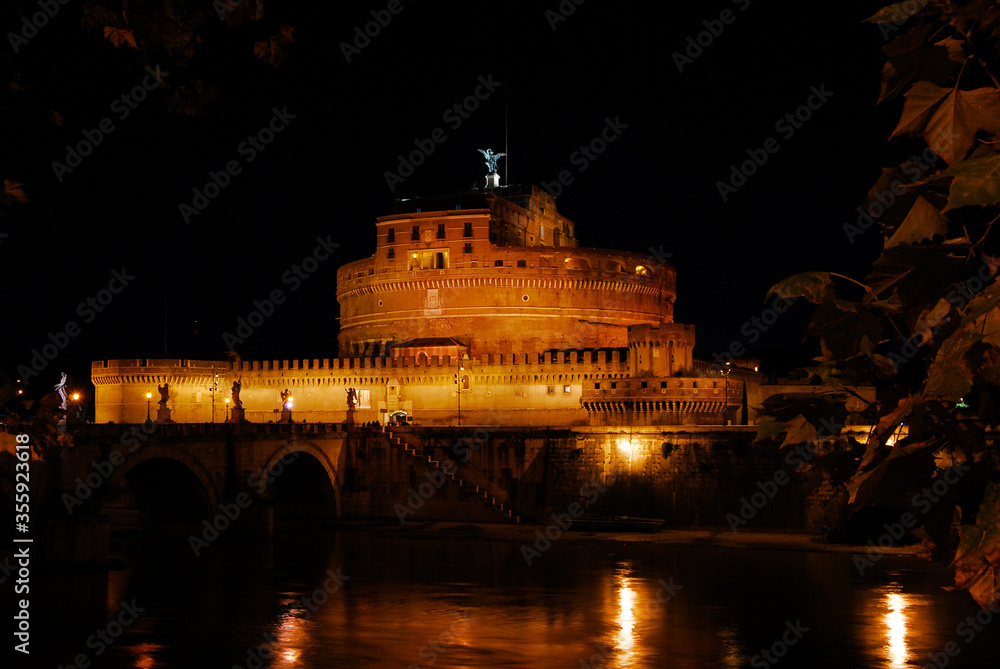 Night view of the famous national monument Castel San'Angelo (Holy Angel Castle) illuminated with River Tiber, in the historic center of Rome