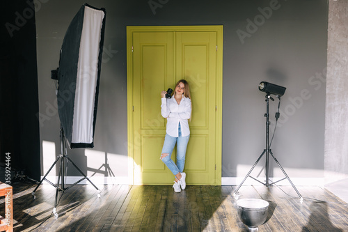 female instructor for  photography classes stand in studio with photo