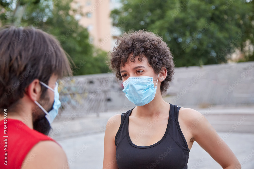 Girl in face mask talking to man