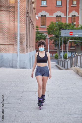 Latin girl skating on inline skates protecting herself with a face mask