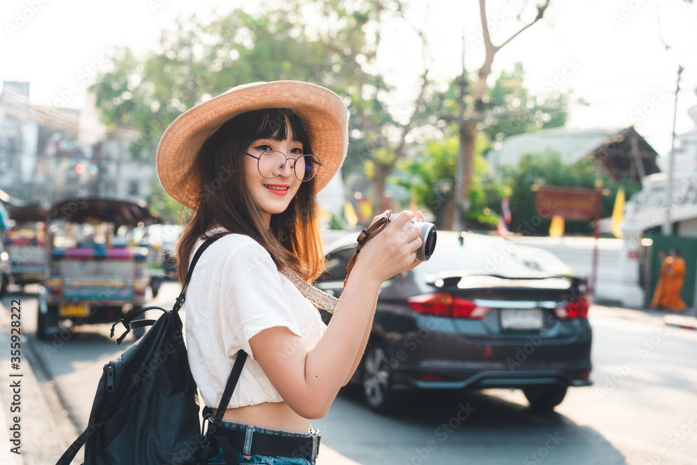 Young asian woman backpack travel in city with camera