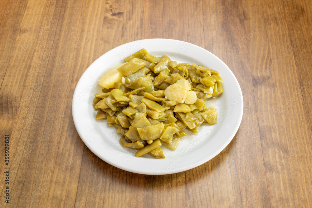 Plate of green beans on wooden table Plate of green beans on wooden table