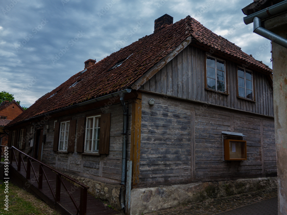 Historical log building with red tiles roof  in Kuldiga, Latvia