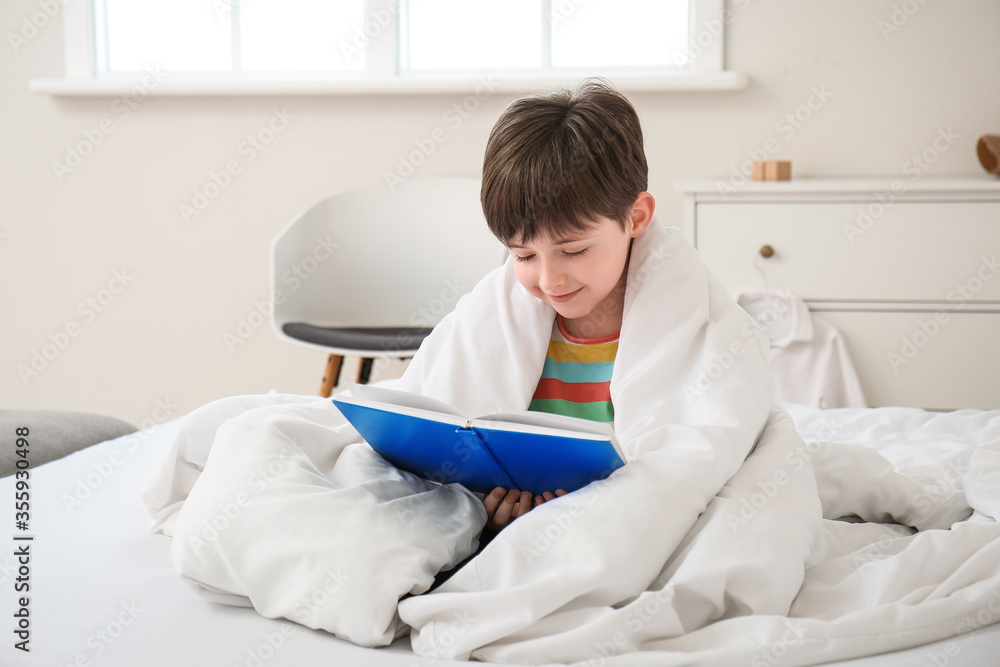 Morning of little boy reading book in bedroom Morning of little boy reading book in bedroom