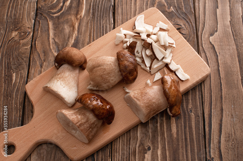group delicious white mushrooms on wooden table, partially chopped.