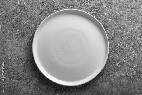Ceramic empty plate on grey concrete background.