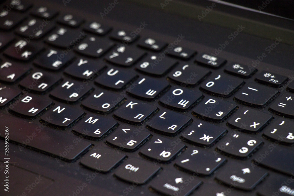 Laptop and notebook computer keyboard close up, texts, keys and black board.
