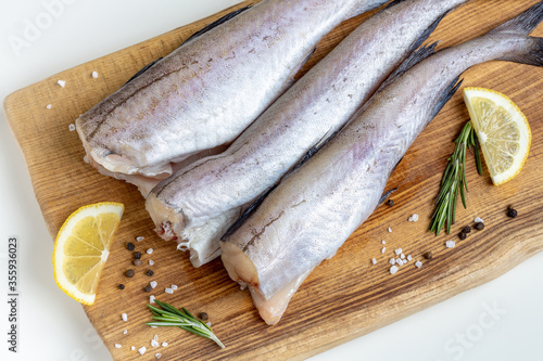 Fotografie Raw fresh pollock fish on a wooden board