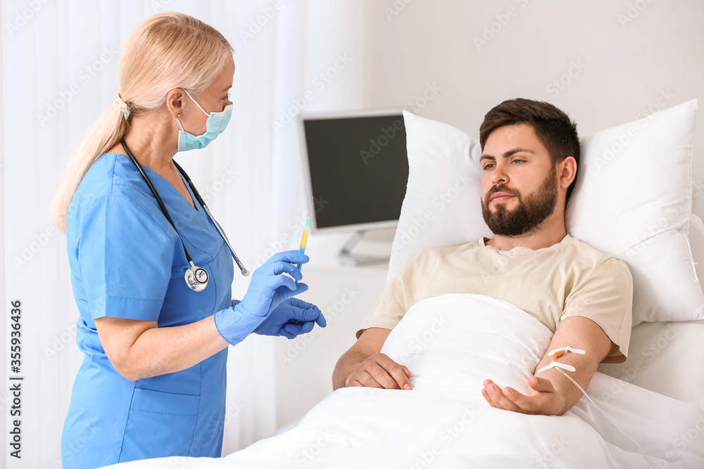 Mature female doctor working with patient in hospital room Mature female doctor working with patient in hospital room