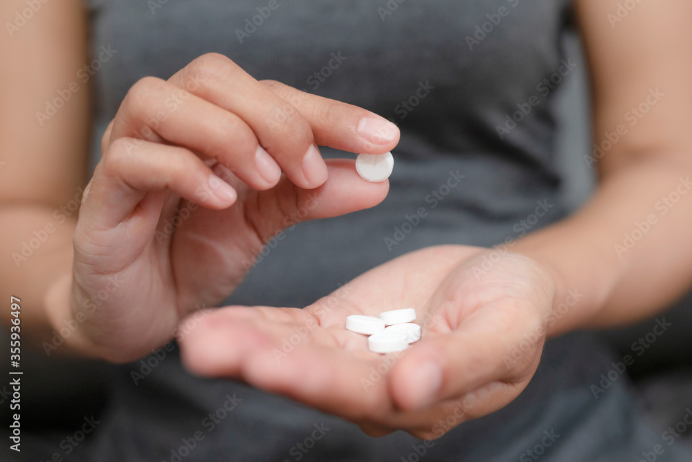 Close up of woman taking in pill she is pours the pills out of the bottle,taking painkiller to reduce sharp ache concept,health care and medicine concept. Close up of woman taking in pill she is pours the pills out of the bottle,taking painkiller to reduce sharp ache concept,health care and medicine concept.